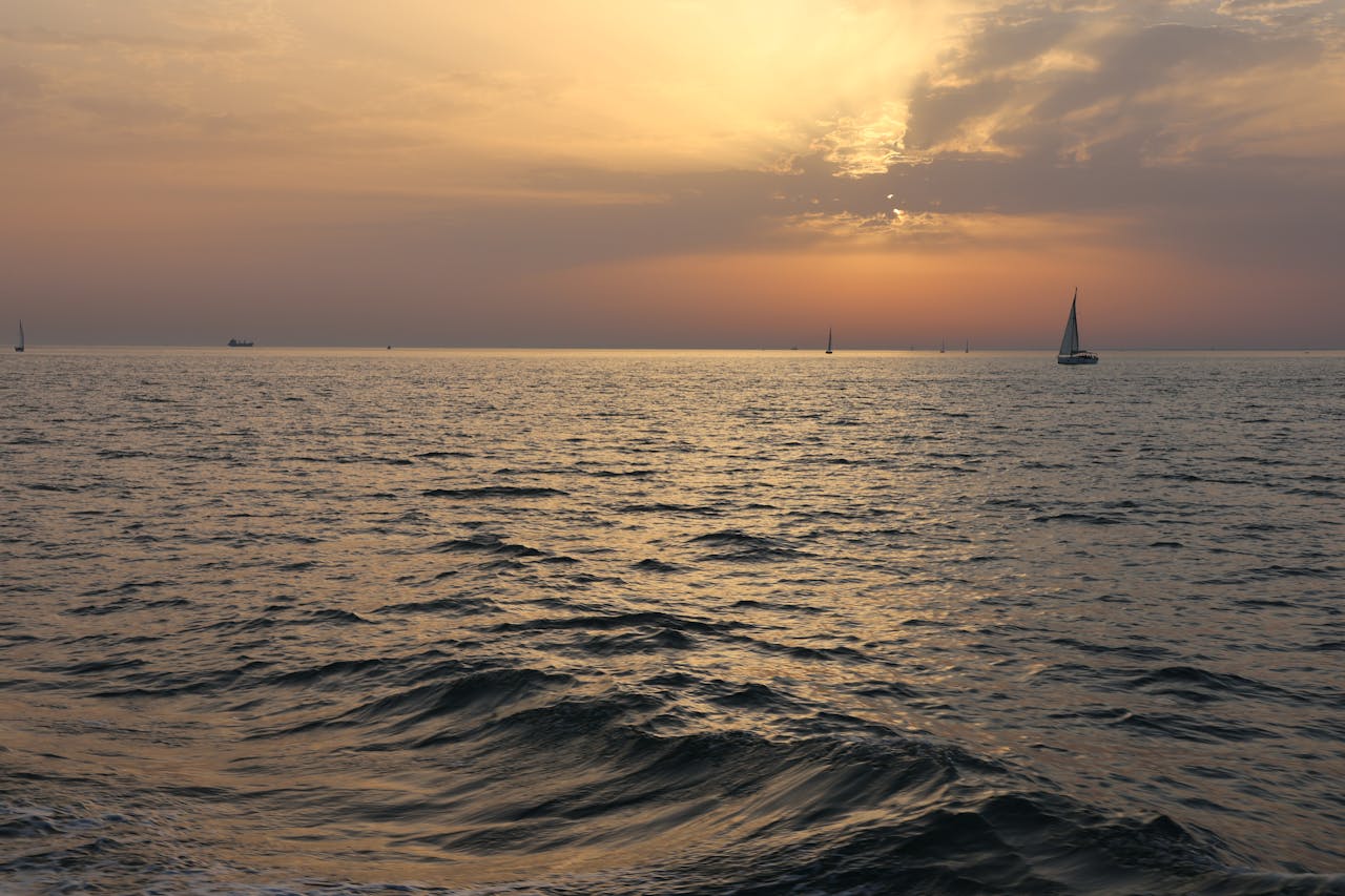 hero-gallery-03 Sailboats drift peacefully on a serene sunset bay in Andalucía, Spain.
